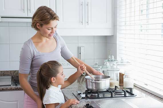 young girl cooking with her mum